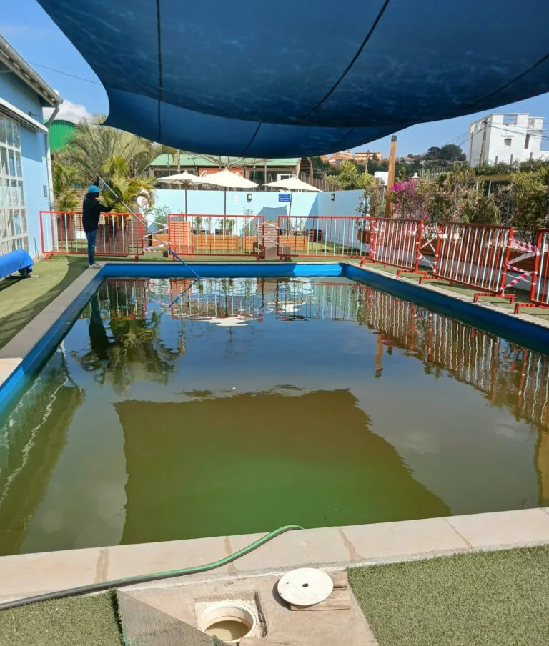 Une personne nettoyant un piscine sale.